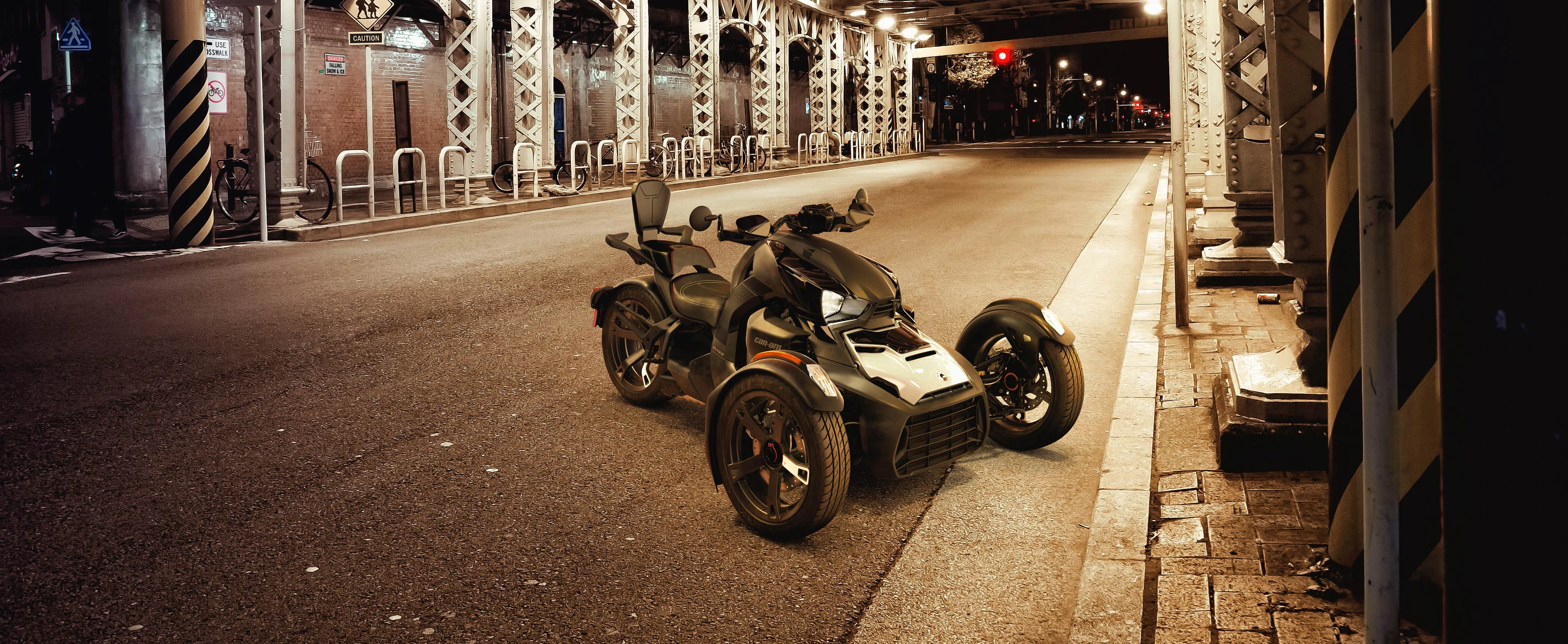 Couple riding on Can-Am Ryker vehicle with yellow shock panels